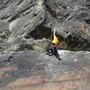 Kathleen Tobelmann reaching over the lip on the crux of "Sagaba" [5.9] with a rope fixed on "Recovering Festival Girl" to the left.