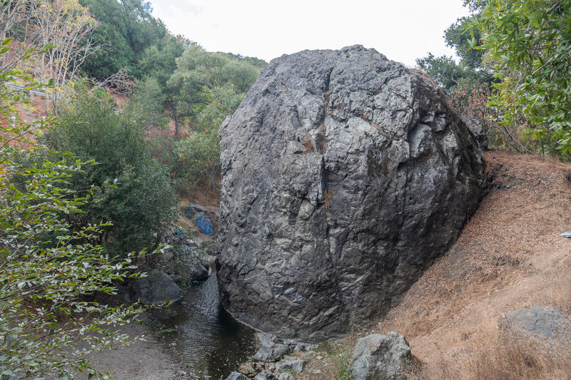 South-East (upstream) side of rock. Hicks Road's guardrails and trail down is visible on the left. Top of rock is easily accessible on the right.