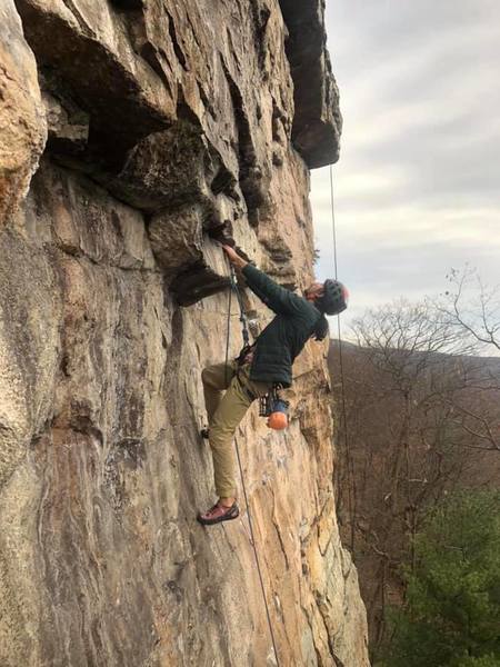 Photo of Ian contemplating the crux (photo taken with permission by @edge_outside)