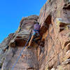 Work your right foot a little wider to the right so that your left foot can jam into the beginning of the crack that is close to my left shin. Trust the holds, lean back, and climb.