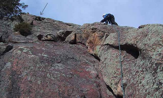 Warren Teissier running it out on the second pitch of the East Face of the Finger Flatiron.  Arrow marks the crux crack of the climb (note also the prominent tree).