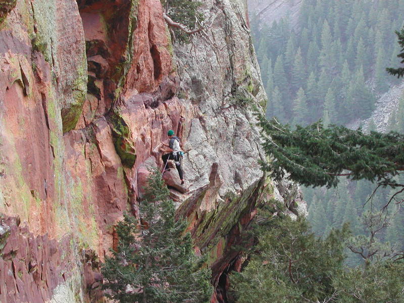 Unnamed climber finishing the traverse at the top of Pitch 1.