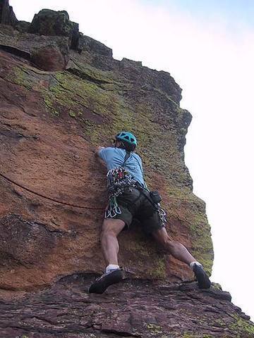 Bill Wright begins to move left after making the reach up to the high horizontal crack.  From the angle of the rope, one can see a fall from here would not be fun.  This photo is about 4' farther right than the last.