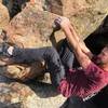 Starting position, lower left side of boulder with both hands on big ledge jug, and left heel on side of boulder. Right foot is placed on a hold below hands.