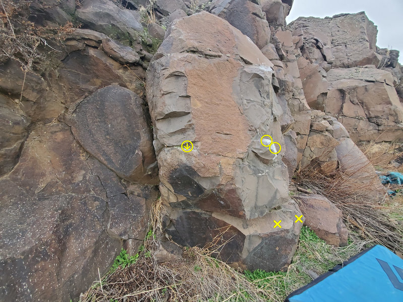 Stony-Faced. Sit start with matched hands in circles and feet on X's. First move is to left-hand crimp on circled arrow.