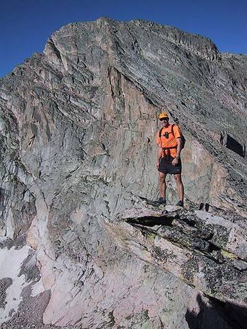 Bill Wright on a "diving board" with the NE Ridge of McHenry's rising above his head.  Taken from a few hundred yards east of the saddle.