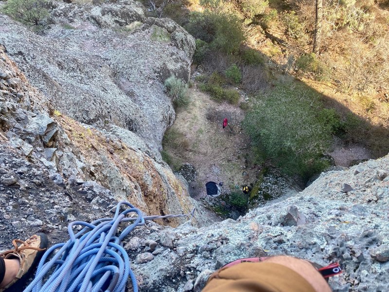 Sitting on the belay ledge of pitch one.  The route climbs up on the right side of photo where it is not overhung.