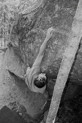 Chip Phillips, completing the long reach move that constitutes the crux, by Justin Jaeger.