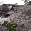 Scott Conner starting up the hand crack.  The crux roof looms above.