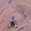 Christa Cline at the start of the difficulties on the first pitch.  Christa has traversed low, and now must make some hard moves up the thin crack to gain the hand crack above.<br>
<br>
Another approach is to climb up to the flake on the right and traverse across higher.  This is less secure, but it avoids the thin crack moves now confronting Christa.<br>
<br>
