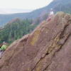 Bruce Hildenbrand climbing to the summit of the Like Heaven pinnacle, belayed by Will Clopton. The new rappel anchor goes down the steep face directly below Will.