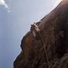 On the crux roof of P2. Note the single cam with long runner well below his feet.