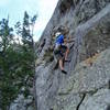 At the first hard move. Undercling, smear, reach up for a decent edge, step left. The route continues with another hard move at the undercling flake up and right from Ken in the photo.