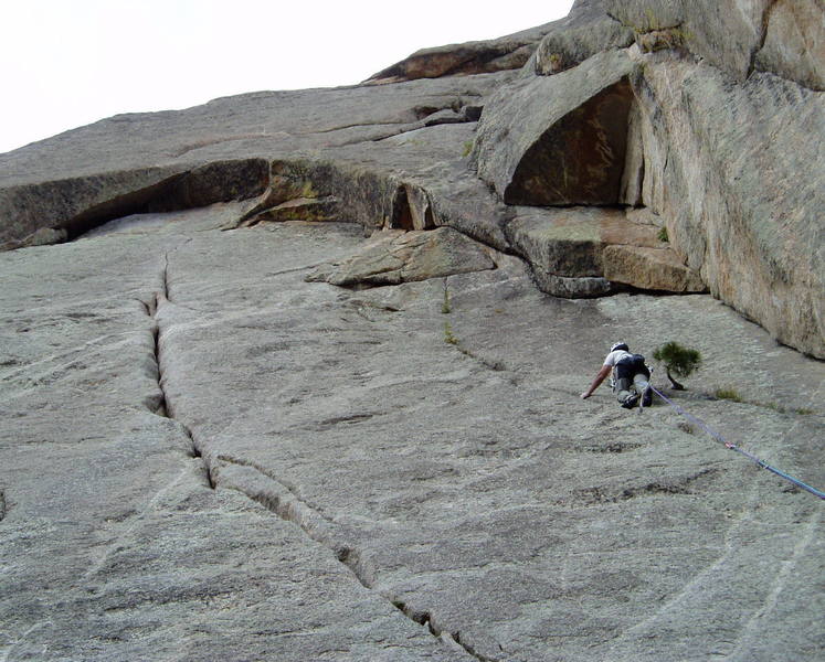 Fat City Crack climbs the rounded crack left of Chuck and then a think crack (10a?) above, traverses left to the wide crack and over the arching roof (10 b/c harder than it looks). High Plains Drifter continues up the slab above. Howling in the Wind climbs the wide crack in the large corner right of Chuck at 5.9 and then moves left at the large triangular overhang into the left facing corner. The thin cracks right of Howling in the Wind are the top of El Camino Real and Corner Pump Station.