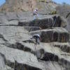 Starting the second crux. The goal is to reach the jug diagonally up and right from Chuck's head. The King Tut crux climbs left of the hanging purple rope at the short left leaning, left facing corner. Lenny Miller belaying.