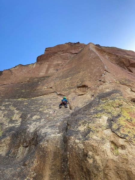 SYZ follows the left trending weakness before heading up and then right to the anchors.  Seven year old Jasper making the route look mega-long!  
<br>

<br>
Moons of Pluto is the arete to the right.  The top of Cosmos can be seen to the left.