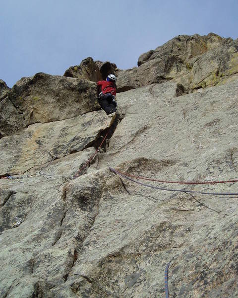 On the 3rd and last pitch. This pitch is 8 or easy 9. It's way runout above the ceiling at the skyline above Chuck with the difficulty depending on how directly you climb. Maybe 5.6 or 7 if you climb straight up. Fun on TR.<br>
<br>
The old bolt is in the groove at the bottom left of the photo. Chuck chose to climb the natural line directly above the belay and right of the bolt, but should you choose to climb directly at the bolt, there is some gear, and the moves at the bolt are not particularly hard.