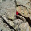 Finishing the crux section. Hand traverse right, stand, and jam back left to get to this point. Eldo of the People, 12a, climbs the ceilings at the far right of the photo to the slab above.