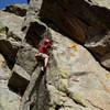 Clipping the 2nd bolt on the arete. The bolts are on the right of the arete, but the climbing is on the left. The anchors for Prism and Scraping By are above the left side of the large roof above Luke. Eldo of the People cuts out right through the large roof to a bolt right of center at the very top of the photo.