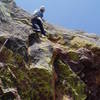 Looking right to where the gear and easier climbing is. A couple moves straight right and it gets easy fast. I've got a good new #5 (purple) Camalot and a good nut at my knees, and a decent red micro Camalot above me. The bolt protecting the crux is at the center left edge of the photo.<br>
<br>
Photo by Chuck Graves.