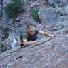 Ian pulls down hard at the top of the West Face. Funky mantle-style move involved.