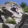 Jen Yuen high-stepping the crux move on the upper face.