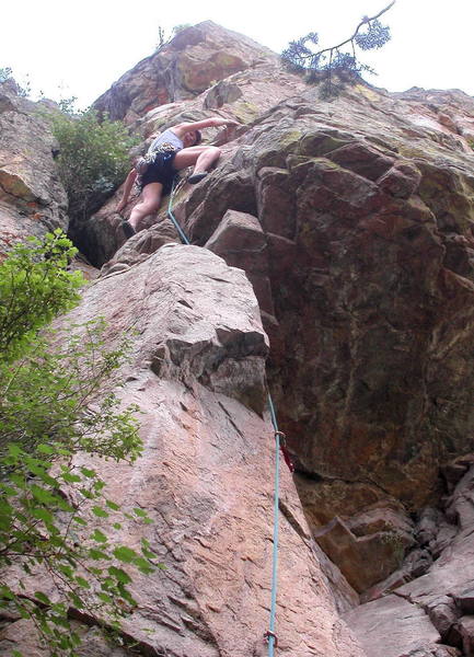 Christa Cline making the crux step right above the roof on The Luminosity.