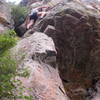 Christa Cline making the crux step right above the roof on The Luminosity.