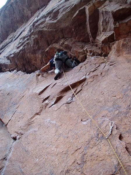 On the kneeling traverse after the crux. Tony has back cleaned a piece and is re-placing it.