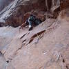 On the kneeling traverse after the crux. Tony has back cleaned a piece and is re-placing it.