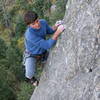 Woody stepping onto the slab at the upper crux.