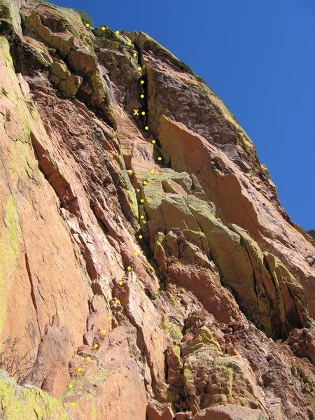 Northumberland Crack, second pitch.  Traverse right on a ledge towards the crack.  Climb up and right through broken rock to a bolt.  Climb the wide crack through a roof (9+) to a stance (optional belay).  Continue up a flared chimney to a ledge with a tree.