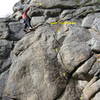 South Beach.  Power up and left on good holds and climb a short finger crack (crux).  Continue up to an overhang, then move left and climb a crack and slab to the anchor.