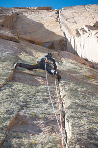 Bruce on the 4th pitch finger crack (11a). The Winter Wall Dihedral is visible up and left, with the Roof Pitch looming on the upper horizon.