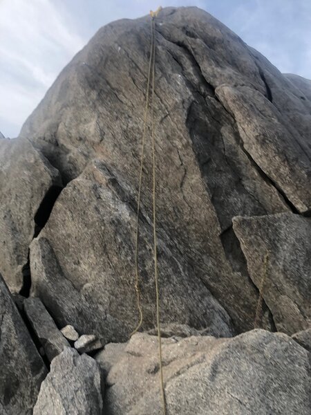 The route goes up slightly to the left of where the rope is lying.