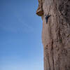 Climber, Alex Jin, pulling up and under at the thin crux.