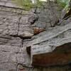 The 5.7 variation goes up the prominent crack directly above the rotted, shredded stump on the ledge. The normal route goes up the thinner crack a few feet to the left.