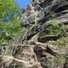 Looking up from the base of Prismaster. Above the climber, the route follows the light-colored, left-slanting crack.