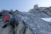 Kyle Hayward pulling through a short steep crack with the summit block in the background