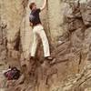 This is a 1981 photo of Curt Shannon on the "Little Flatiron" problem.  Gill did indeed alter a sharp hold on this route with a piton hammer.  It was not, however, in the upper right crack, as stated above--rather it was in the upper left crack.