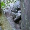 The apron of Jungle Gym starts between the tree and the wall and follows the crack up to another pine tree.