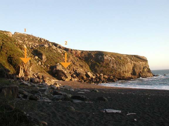 The main bouldering rocks as seen from where the path meets the beach. 1) Warmup Wall 2) Main bouldering rock.  Sand is at medium height at picture time.